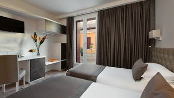 A hotel room with a bed, a desk, a TV, and a view of the outside.