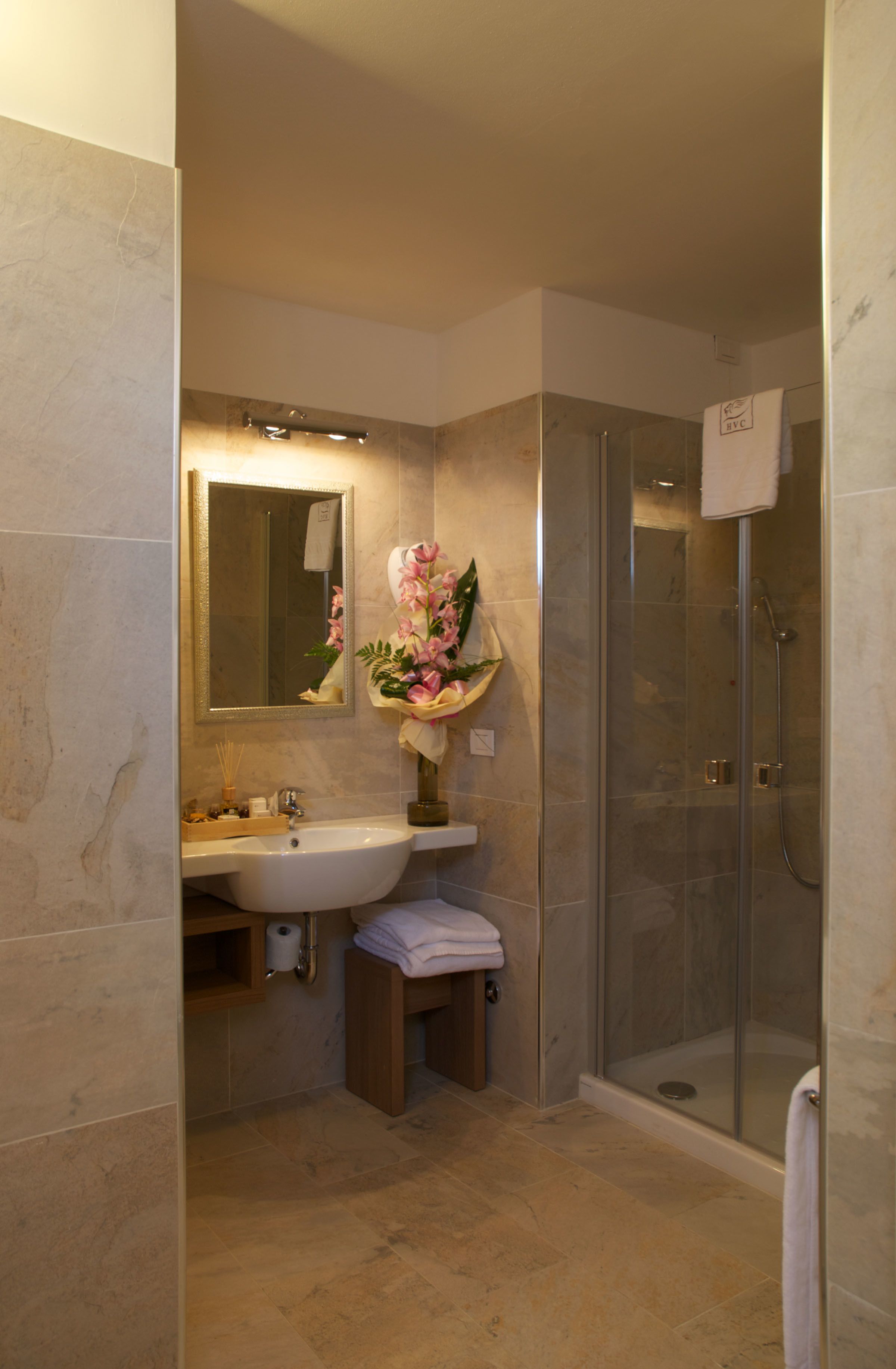 A bathroom with a sink, mirror, and shower.