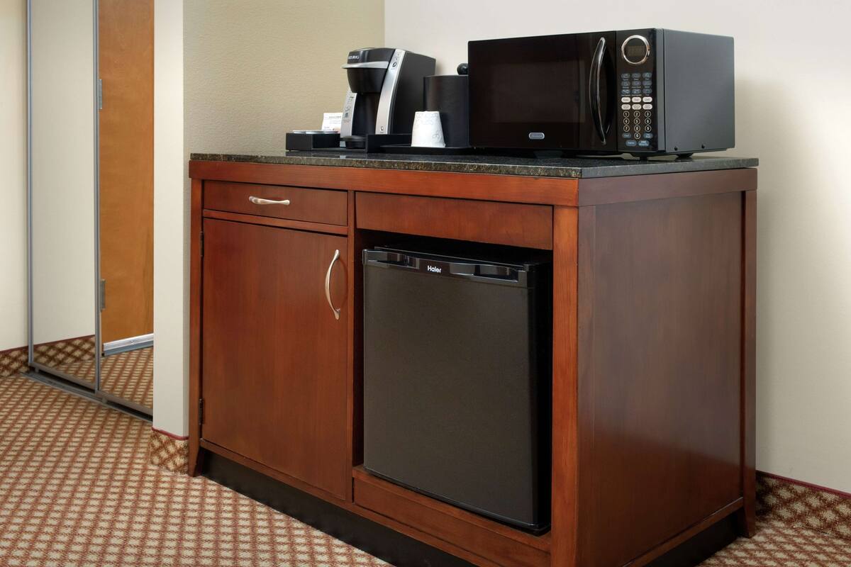 Una cocina compacta equipada con cafetera, microondas y lavavajillas.