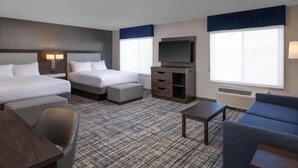 A hotel room with two beds, a TV, a desk, a chair, and a sofa. - Hampton Inn & Suites Manteca (Manteca)
