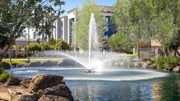 A fountain in a park with a building in the background. - Hampton Inn & Suites Manteca (Manteca)