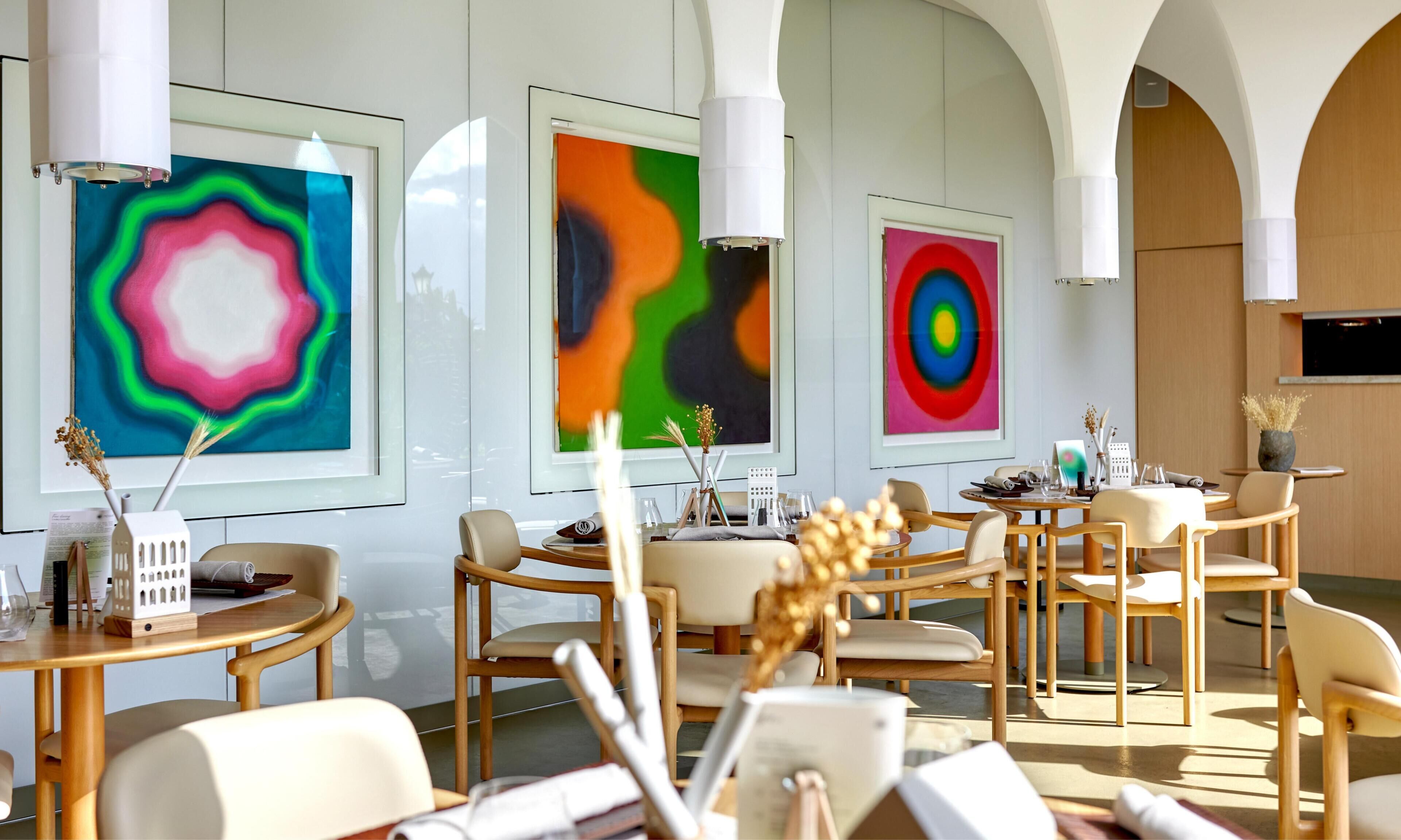 A modern interior with art on the walls, wooden furniture, and a spacious layout.