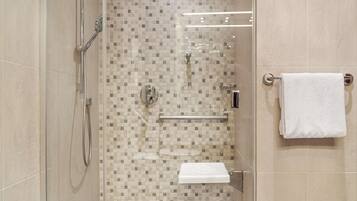Un baño moderno con cabina de ducha de vidrio, inodoro y perchero.