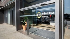 A B&B hotel entrance with a modern design, glass facade, and a visible parking area. - B&B Hotel Granada (Pulianas)