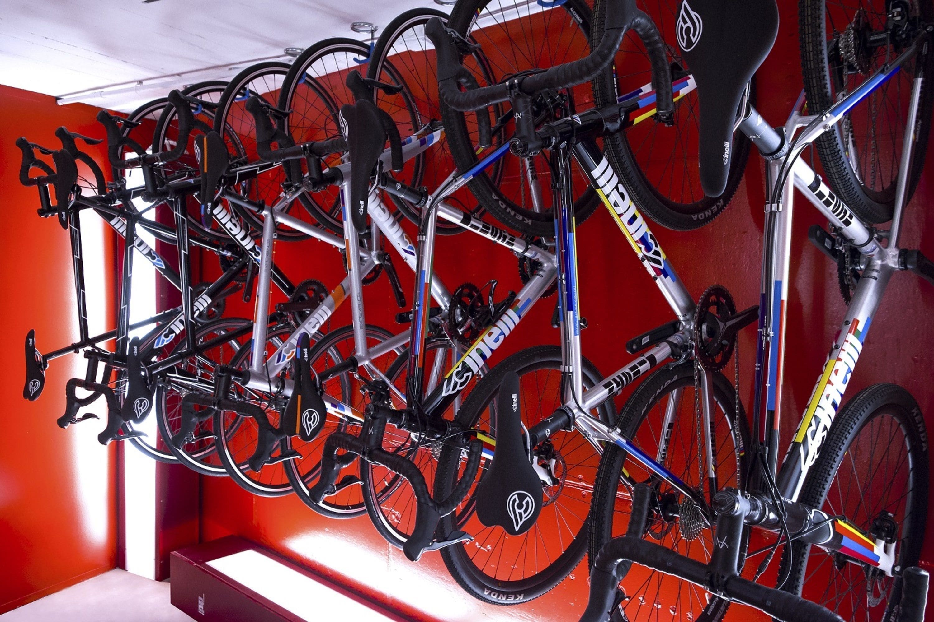 Un perchero para bicicletas montado en la pared con varias bicicletas.