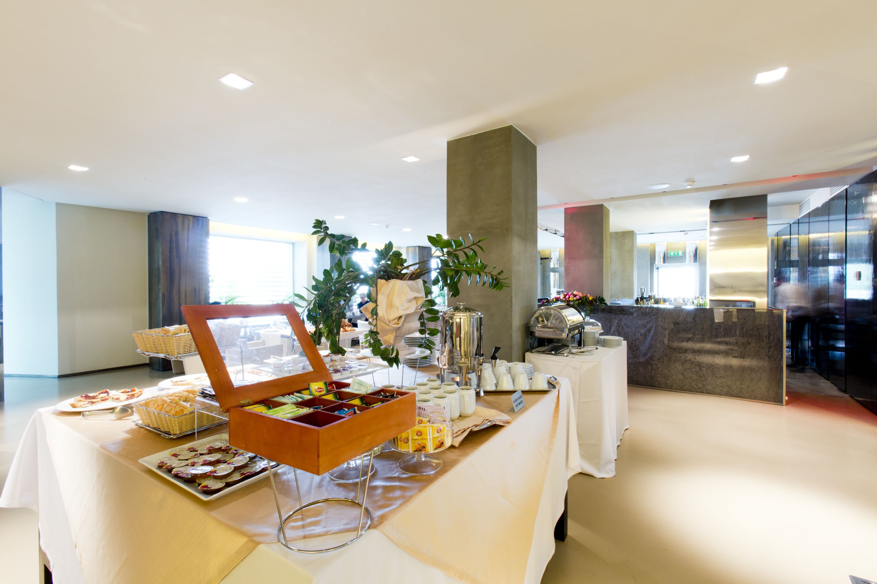 Een buffetopstelling met diverse gerechten en een koffiehoek in een moderne hotelkamer.