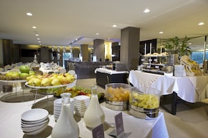 A buffet with various fruits and beverages, including apples, pears, and a bottle of milk.