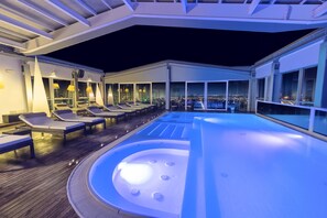 Una piscina techada, sillones reclinables de piscina