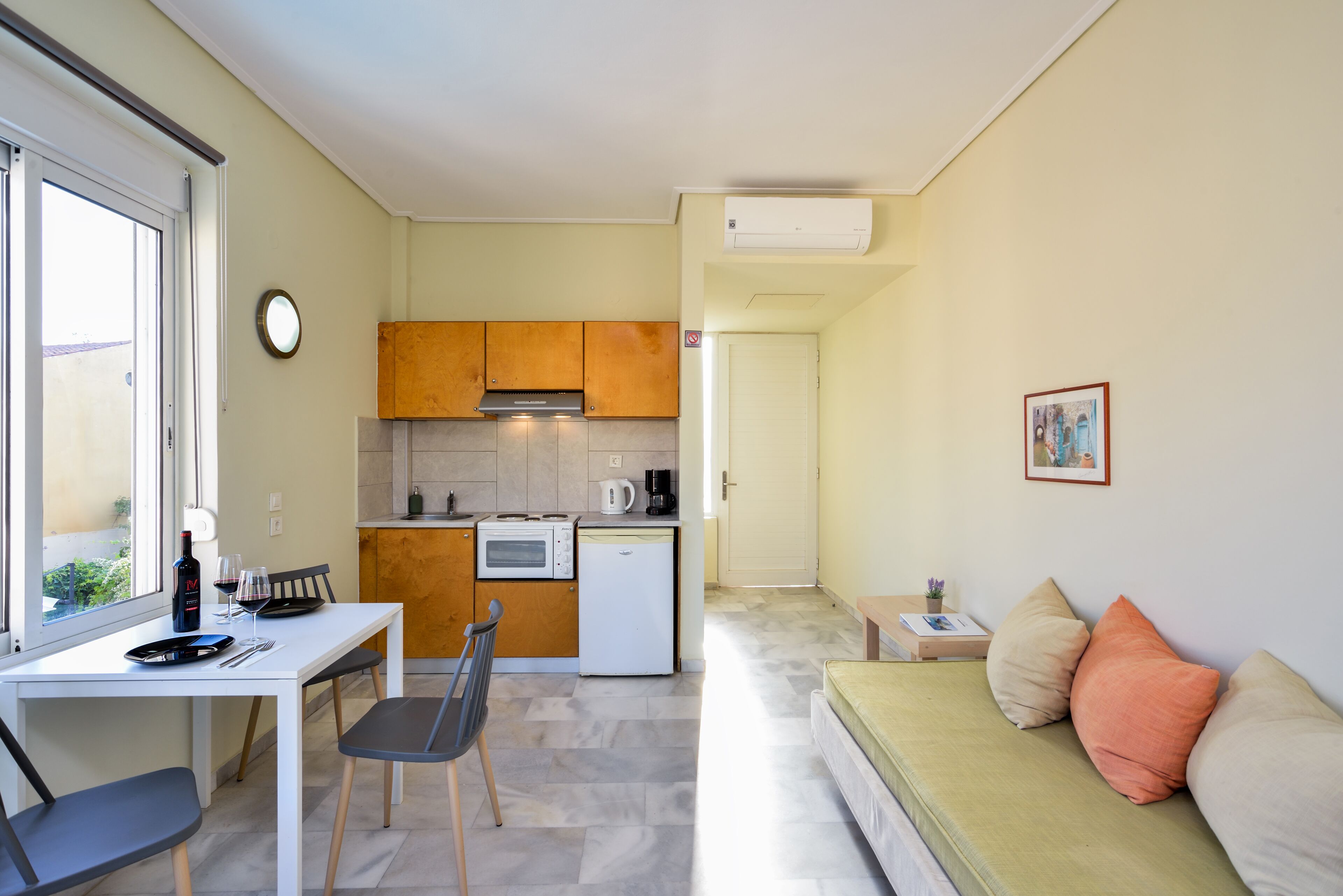A compact living space with a kitchenette, dining area, and a sofa.