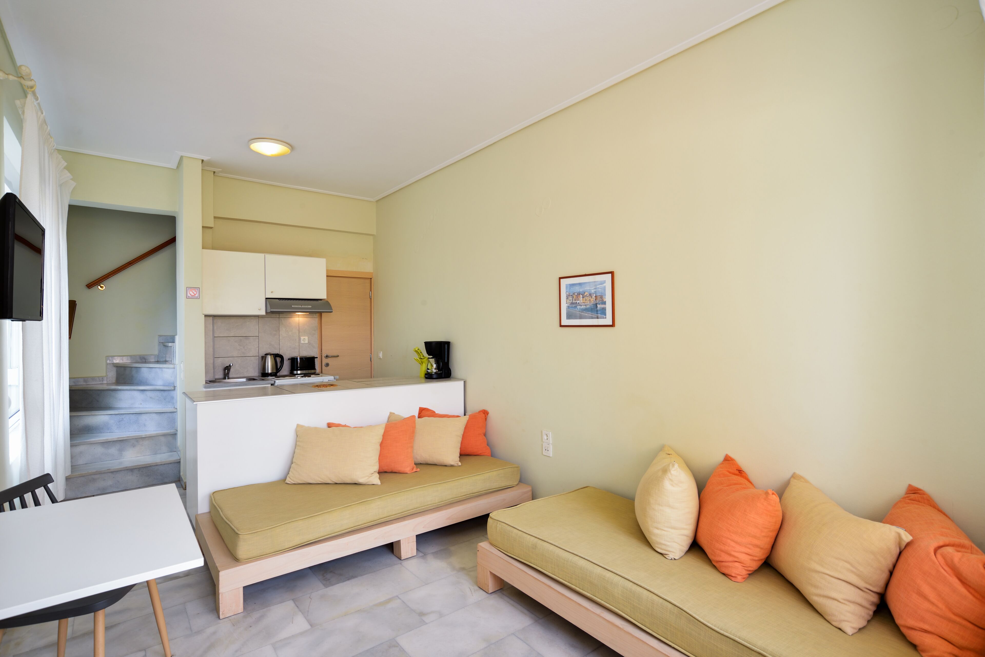 A compact living space with a sofa, a dining table, and a kitchenette.