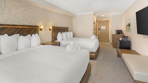 A hotel room with two beds, a desk, a bench, and a TV. - Velora Hinton, an Ascend Collection Hotel (Hinton)