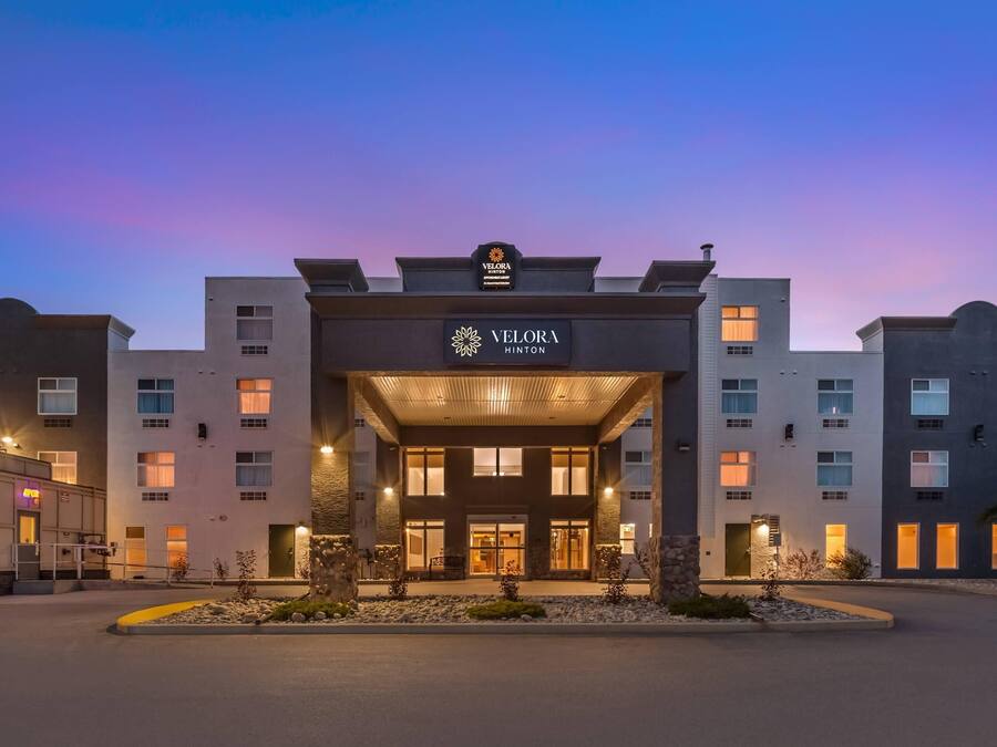 A hotel entrance with a modern design, featuring a prominent sign and a welcoming entrance.