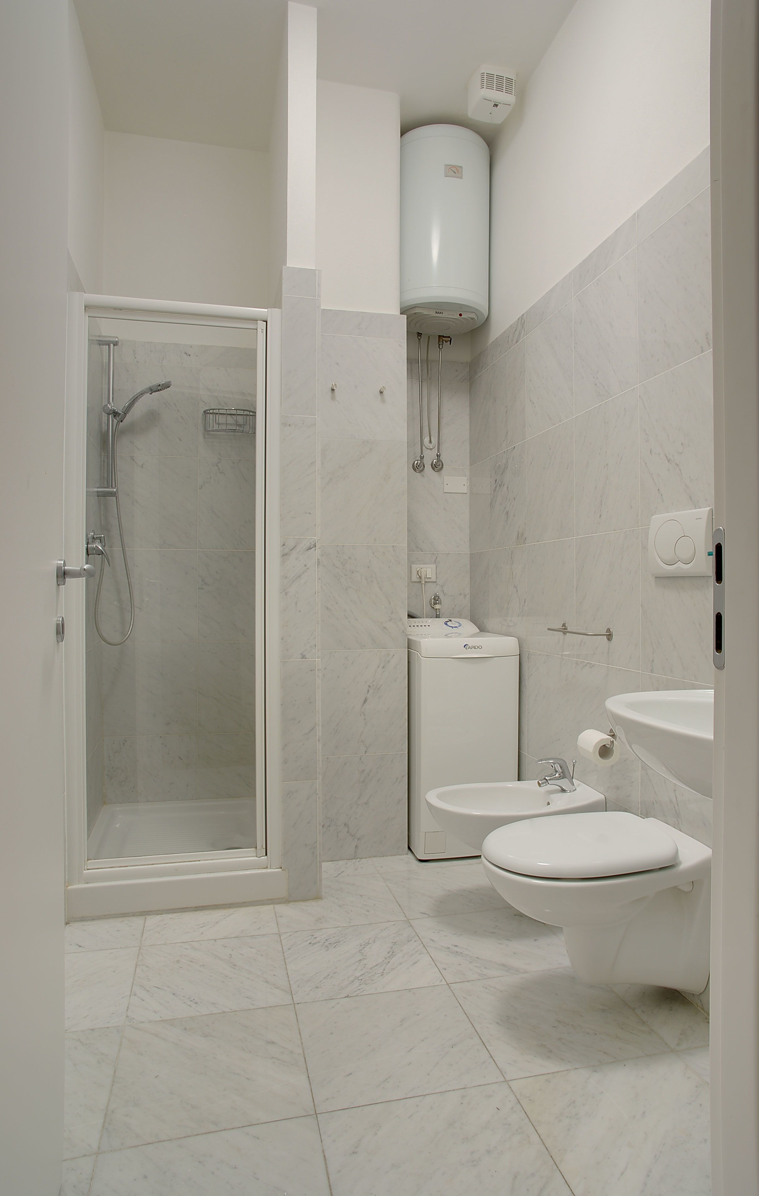Ein modernes Badezimmer mit einer Glaskabine zur Dusche, einer integrierten Toilette und einem Waschbecken.