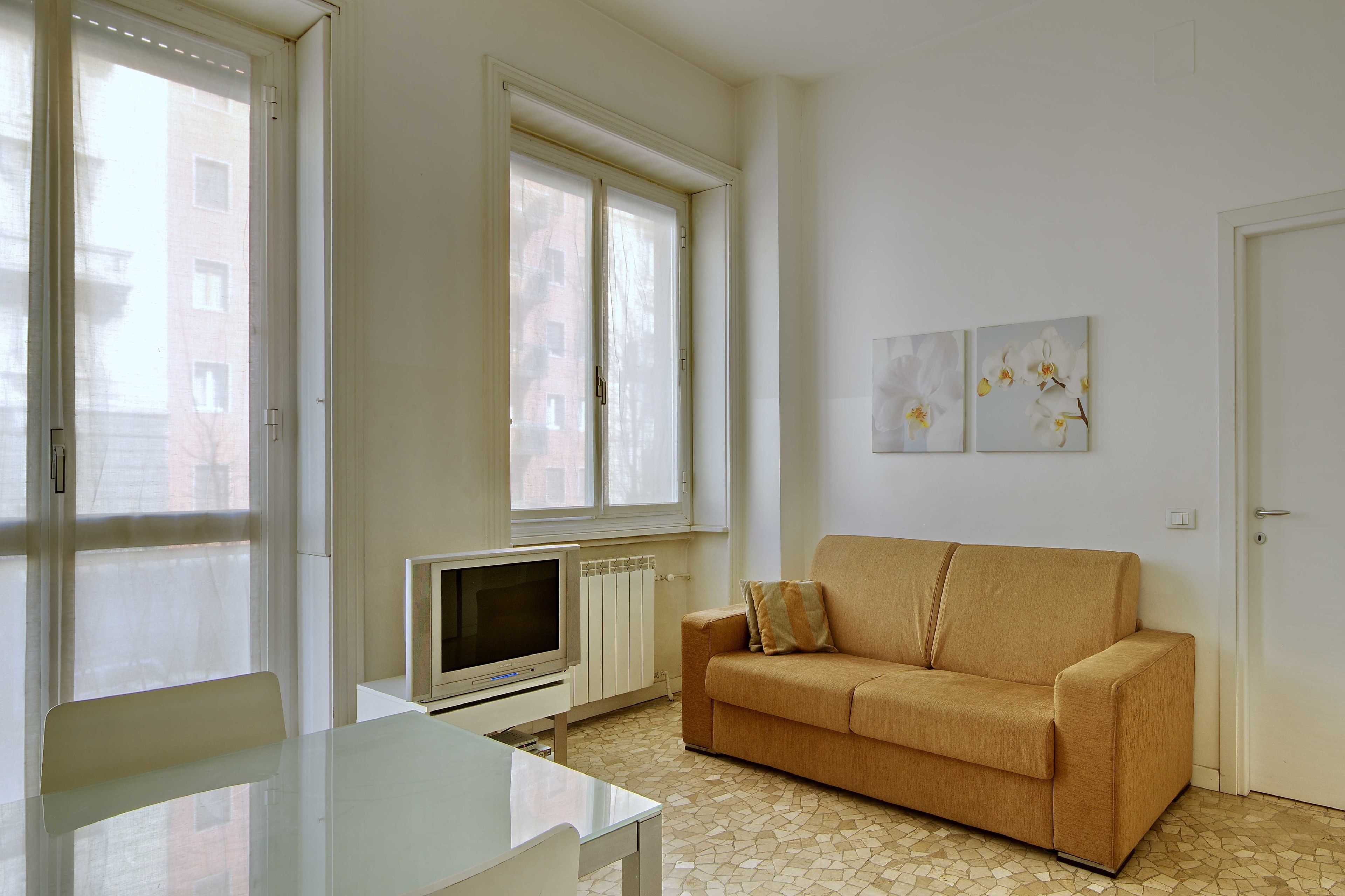 Ein Wohnzimmer mit einer Couch, einem Fernseher und einem Tisch.