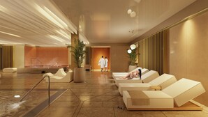 Un espace spa moderne comprenant des fauteuils inclinables, un hammam et un comptoir d’accueil.