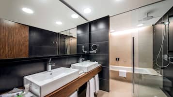 A modern bathroom with two sinks, a shower, and a glass-enclosed shower area.