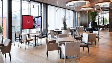 A spacious indoor dining area with modern furniture and large windows.