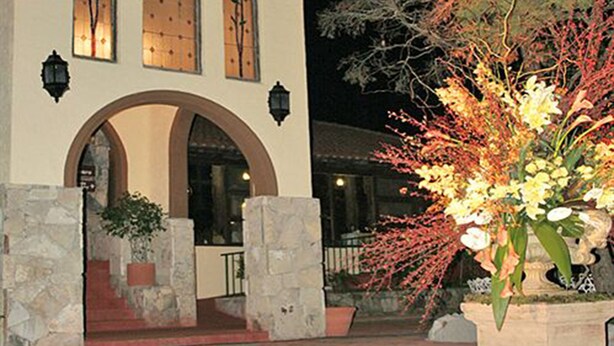 A building with a stucco exterior, arched entrance, and decorative windows. - Hotel Chipinque (San Pedro Garza García)