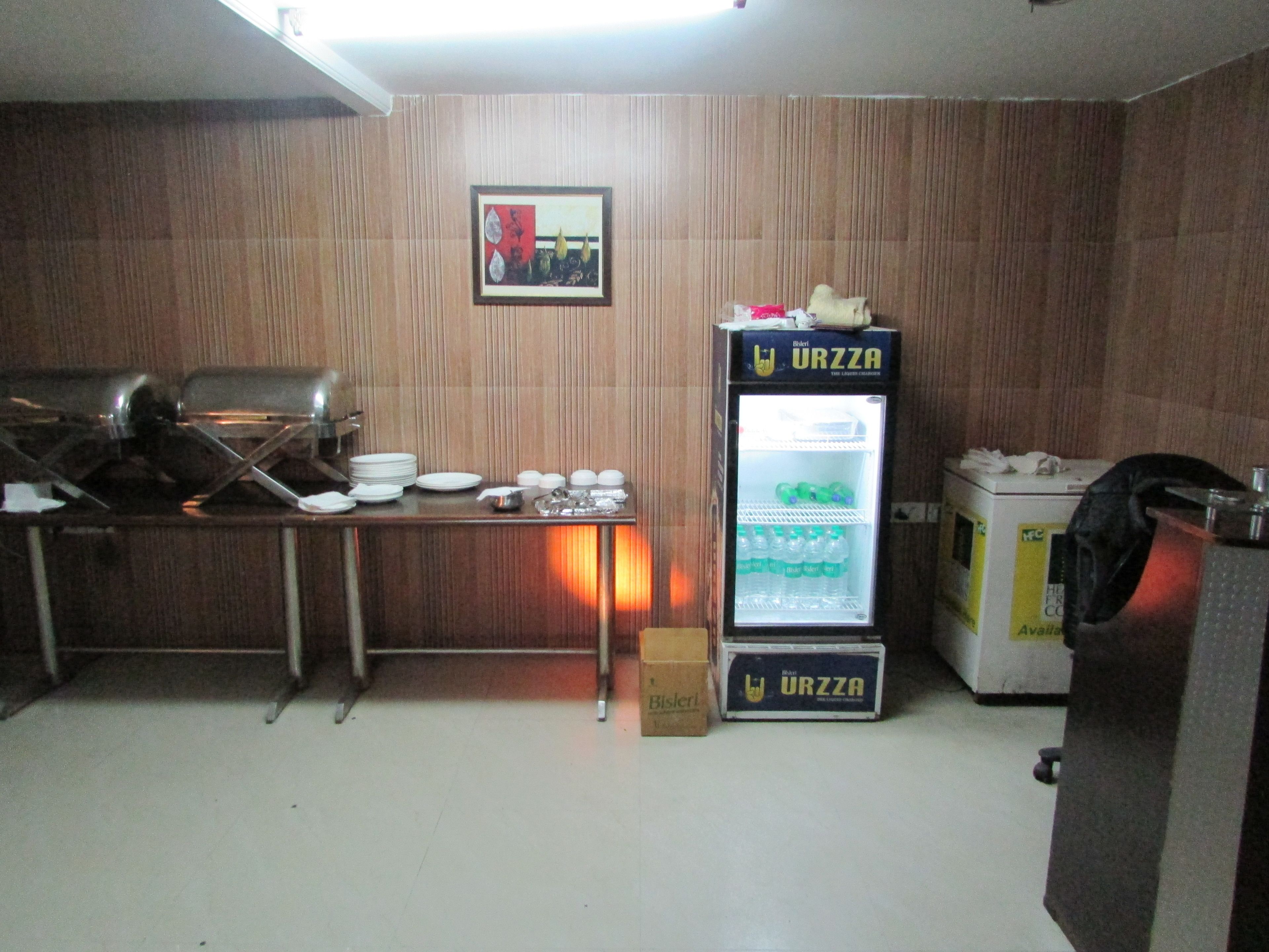 A kitchenette with a refrigerator, a microwave, and a sink.