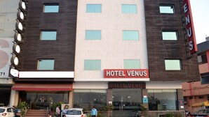 A hotel named 'Hotel Venus' with a modern facade, multiple windows, and a visible entrance.