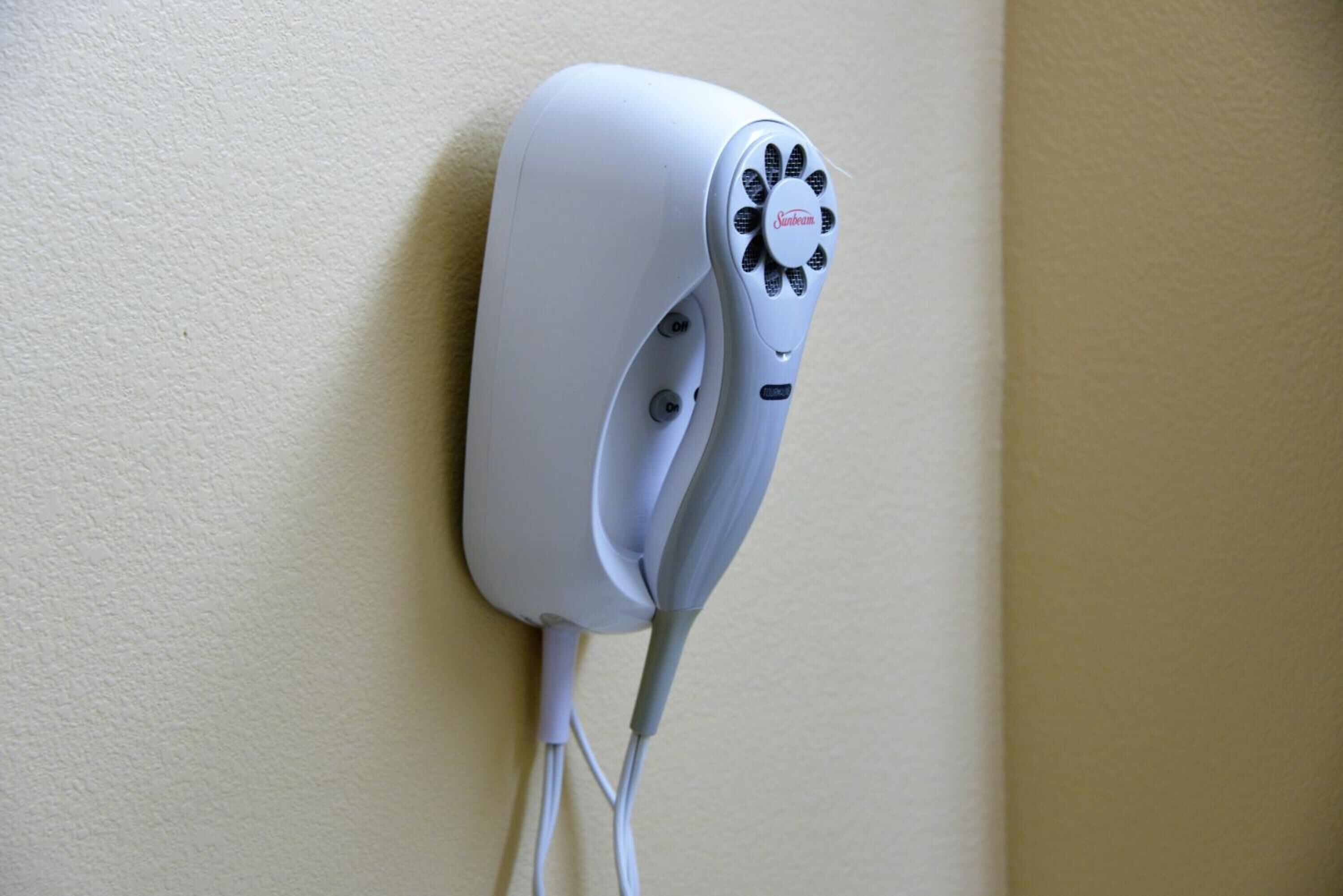 A white device mounted on a wall with a circular design and a label.