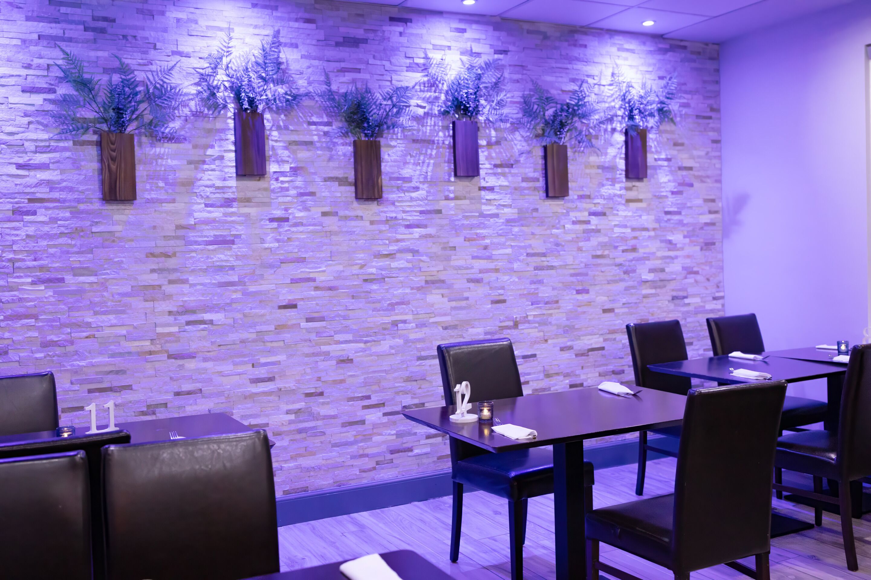 Un restaurant avec un mur en briques, des tables et des chaises en bois.