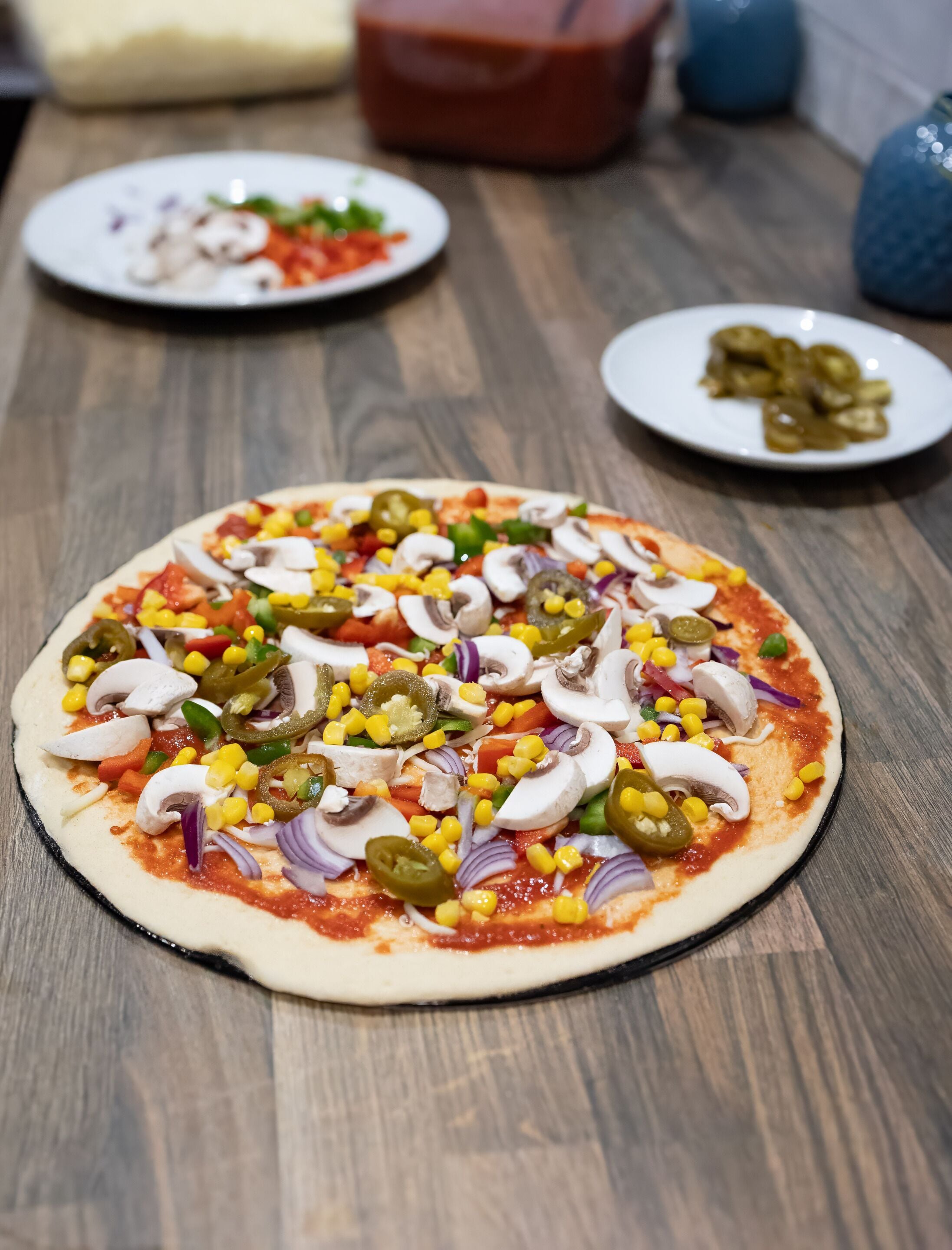 En pizza med olika sorters pålägg på ett träbord.