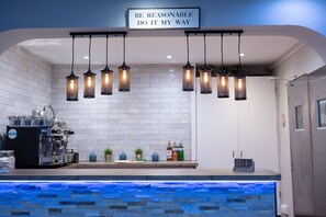 A modern kitchen with a stone countertop, hanging pendant lights, and a sign above stating "BE REASONABLE DO IT MY WAY". - The County Hotel (Helensburgh)
