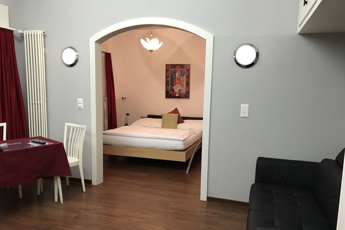 Una habitación con una cama, una mesa y una silla.