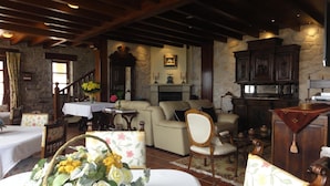 A cozy living room with a fireplace, wooden furniture, and a staircase leading upstairs. - Mirador de Moriyón (Villaviciosa)