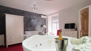 Een moderne badkamer met een vrijstaand bad, een champagnefles en een glas champagne.