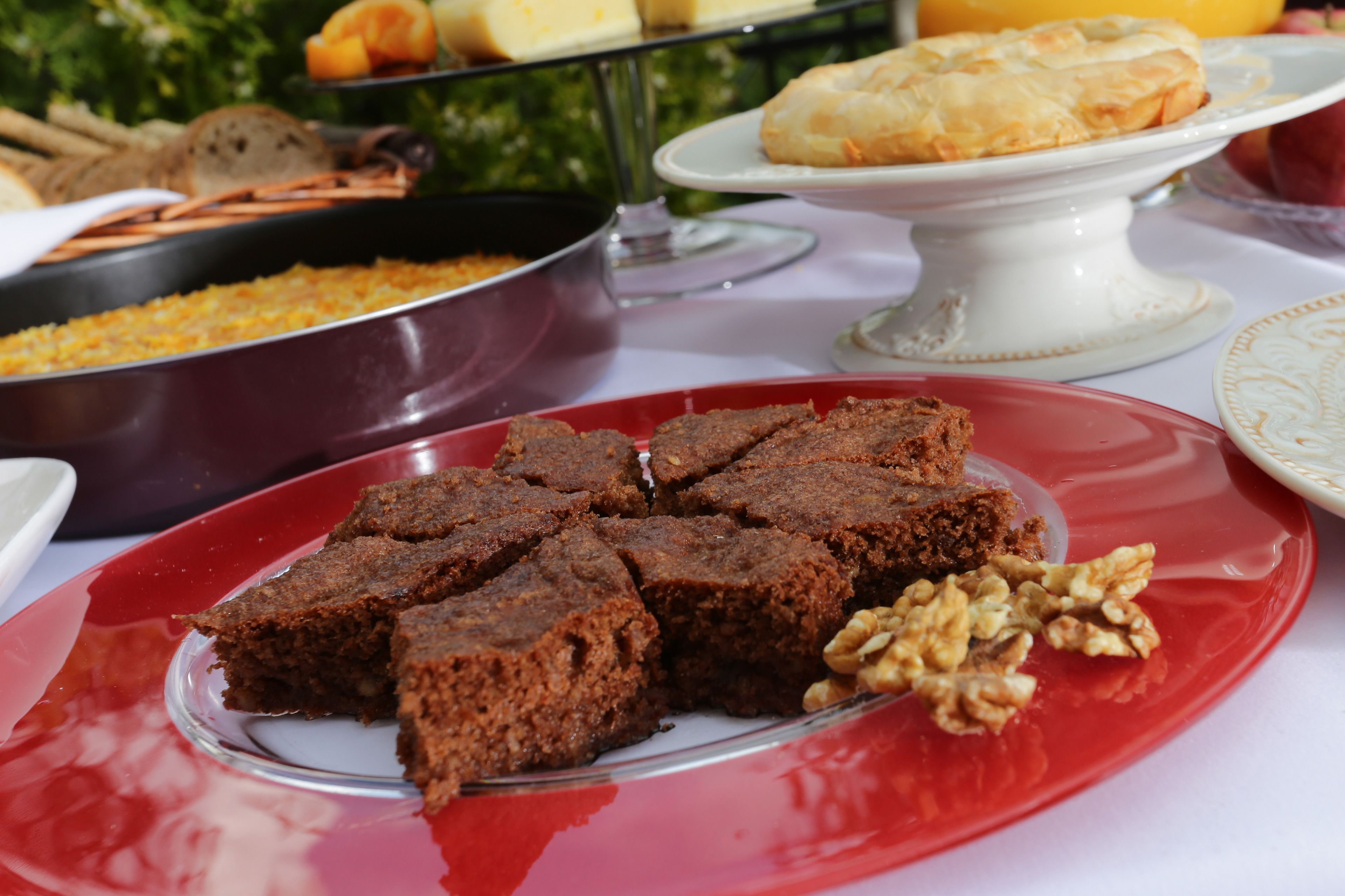 Une table sur laquelle on trouve divers aliments, notamment des brownies et une assiette de noix.