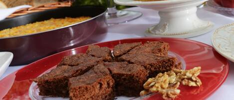 Une table sur laquelle on trouve divers aliments, notamment des brownies et une assiette de noix.