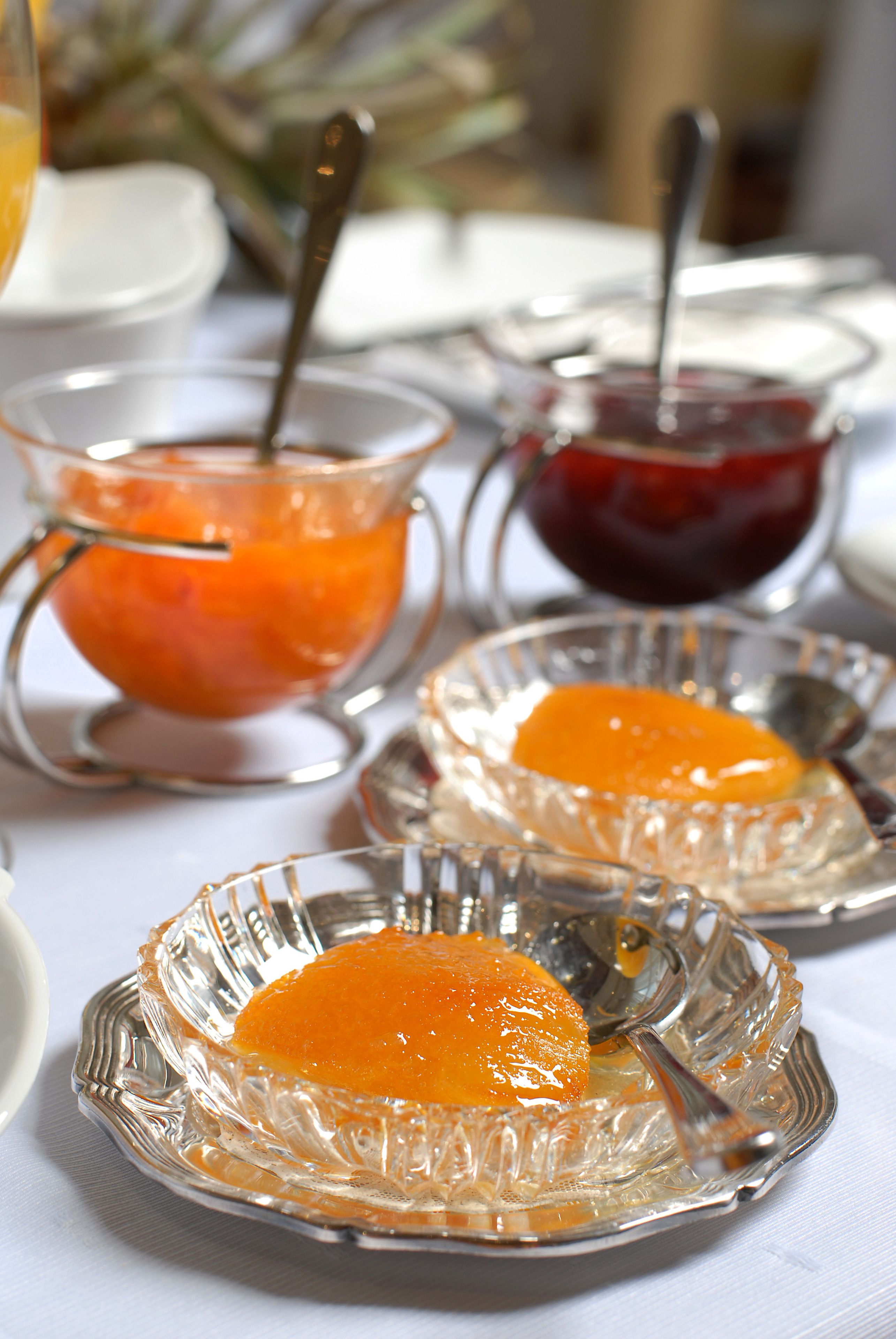 A table with clear glass dishes containing orange-colored food items, accompanied by spoons.