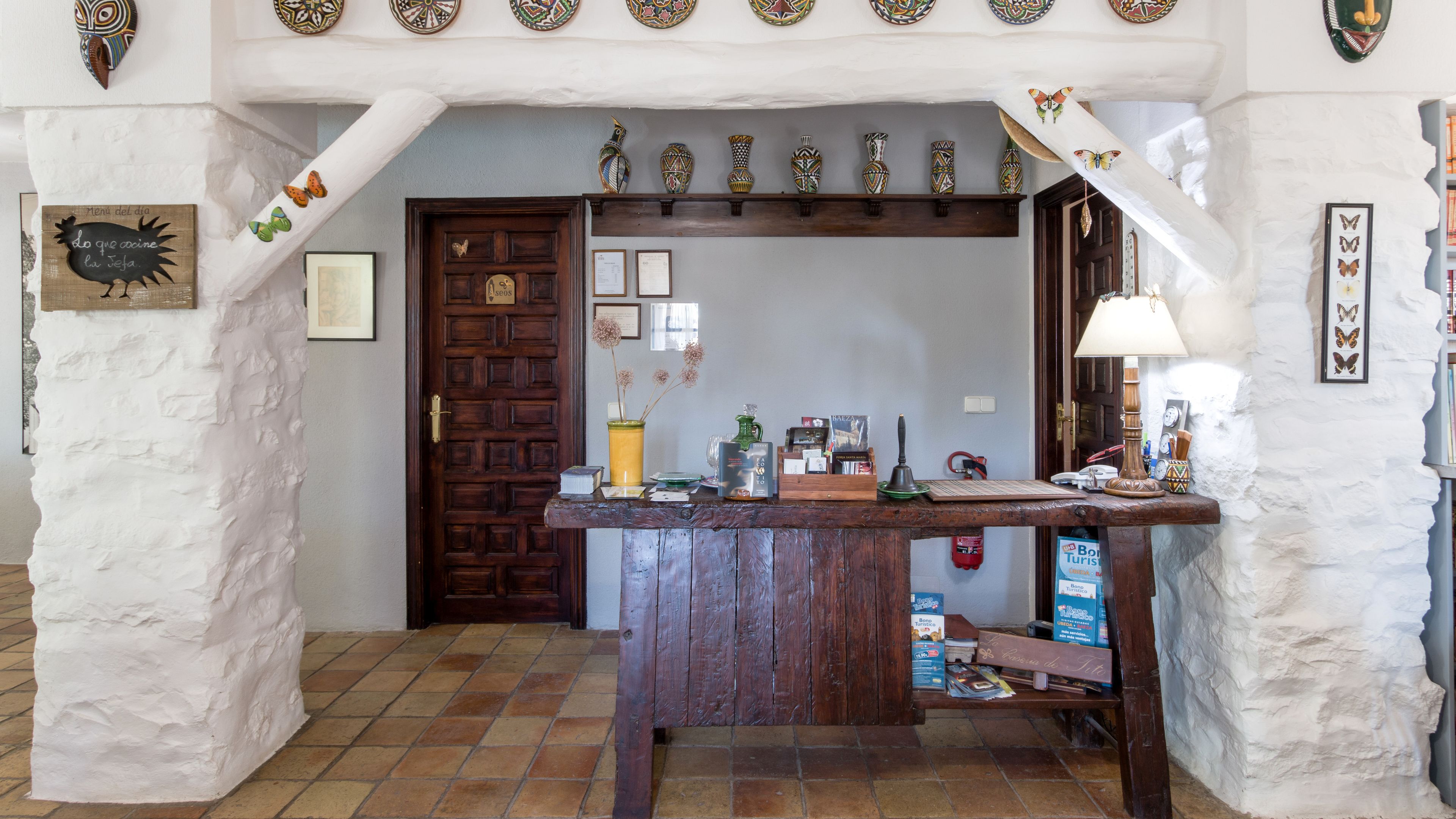 A rustic interior with a wooden counter, a door, and various decorative items.