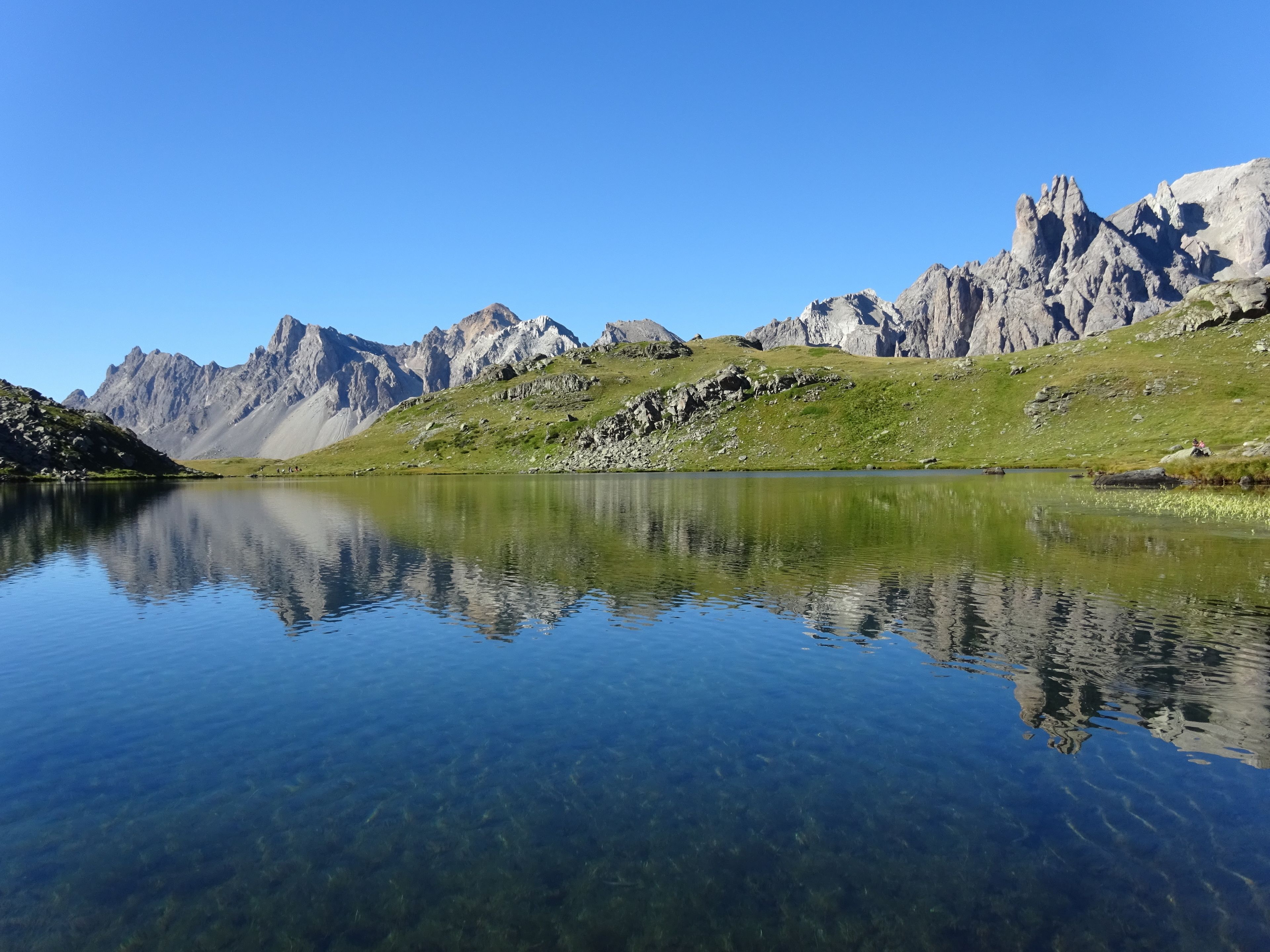 A clear mountain lake with rocky mountains in the background.