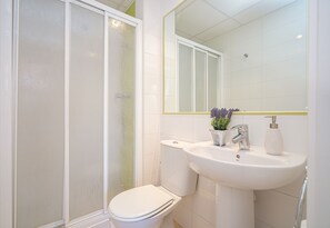 Un baño con inodoro, lavamanos y ducha.