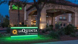 A hotel sign with the name "La Quinta by Wyndham" and a sun logo. - La Quinta Inn & Suites by Wyndham Las Vegas Airport South (Las Vegas)