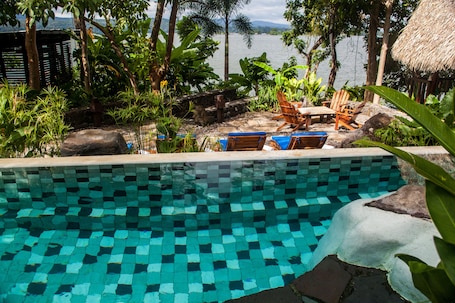 Una piscina al aire libre, sillones reclinables de piscina