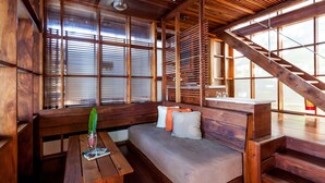 Un interior de madera con sofá, banca y escalera.