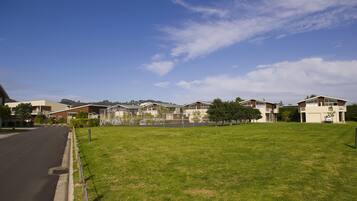 Stylish townhouses line the quiet street with a grassy median and sidewalk.