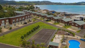 A residential area with multiple two-story houses, a tennis court, and a swimming pool.