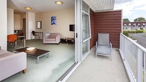 A balcony with a sofa, armchair, and a small table.