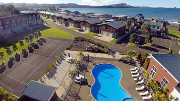 Residents can enjoy a relaxing pool area with lounge chairs and a deck overlooking the sea.