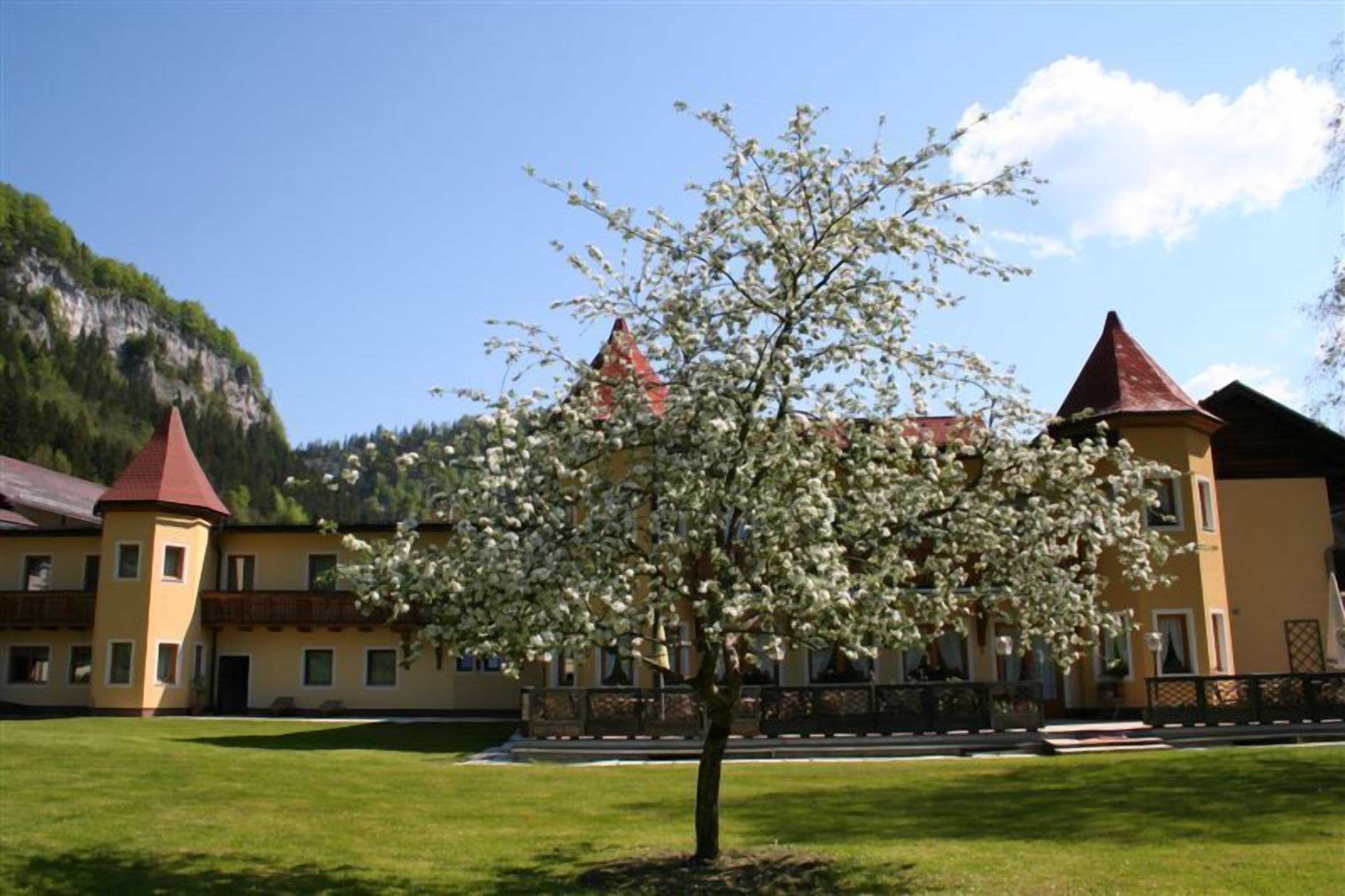 A building with a traditional architectural style, featuring a central courtyard with a tree in bloom.