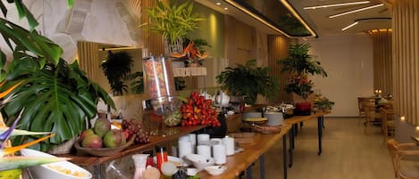 A buffet setup with various fruits, vegetables, and beverages.