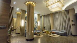 A modern lobby with a large mirror, a round table, and a sofa. - Hotel Soratama (Pereira)