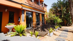 A two-story building with a balcony, outdoor seating area, and potted plants. - Albatross Guest House (Cape Town)
