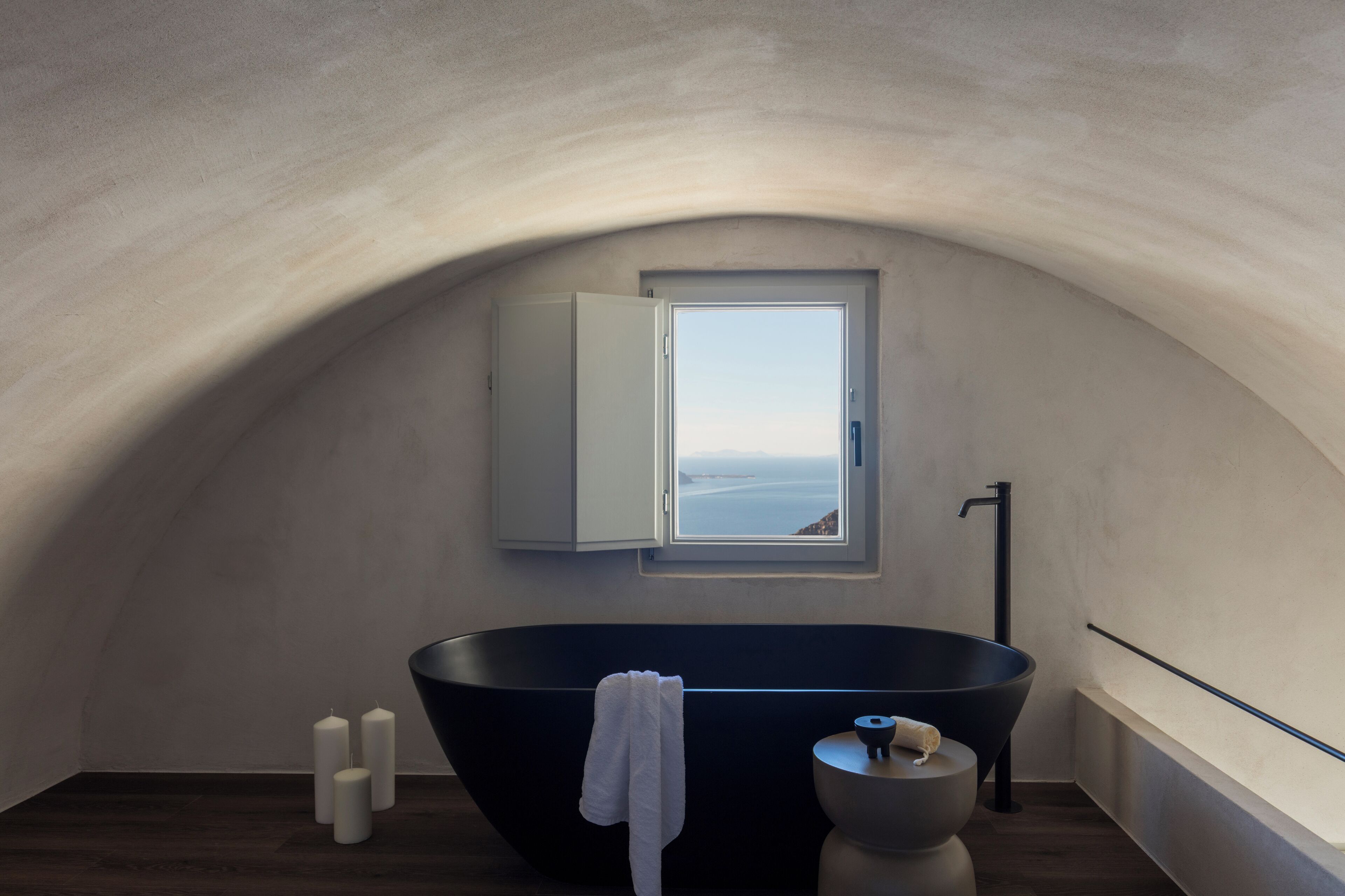 A modern bathroom with a freestanding bathtub, a window with a view, and a minimalist design.