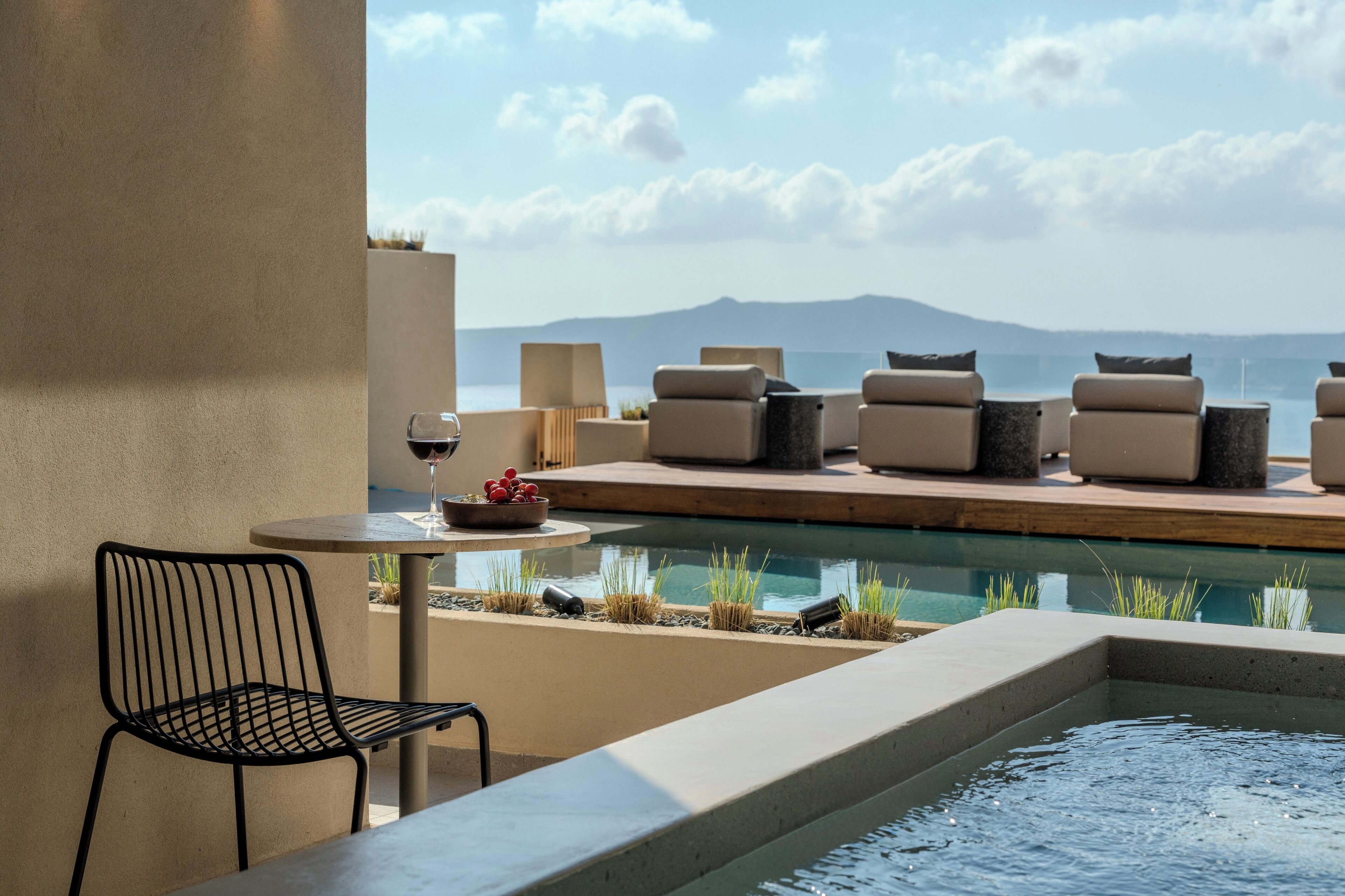 A poolside area with lounge chairs, a table, and a chair.